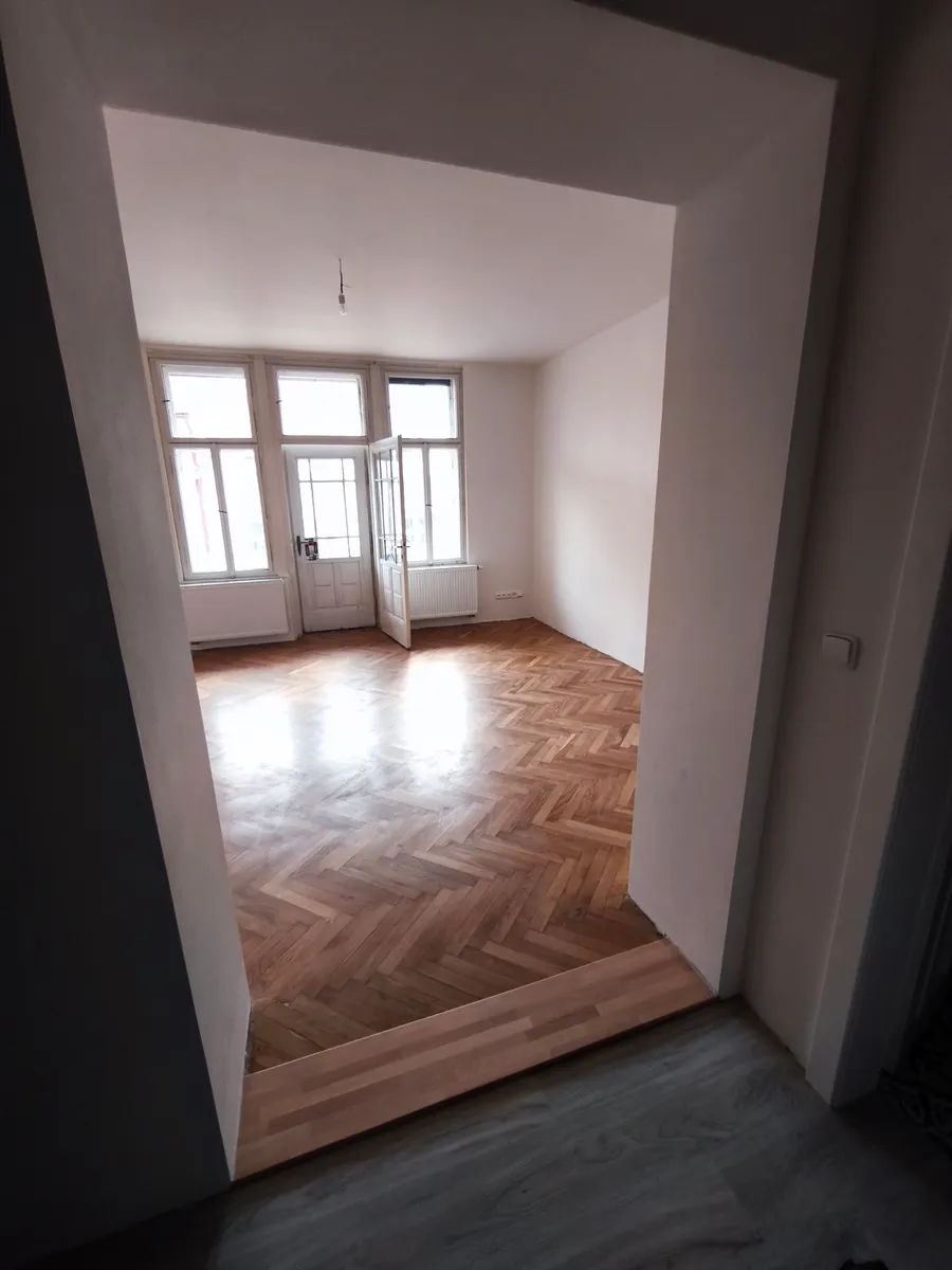 Zrekonstruovaný pokoj s novým radiátorem a parketovou podlahou